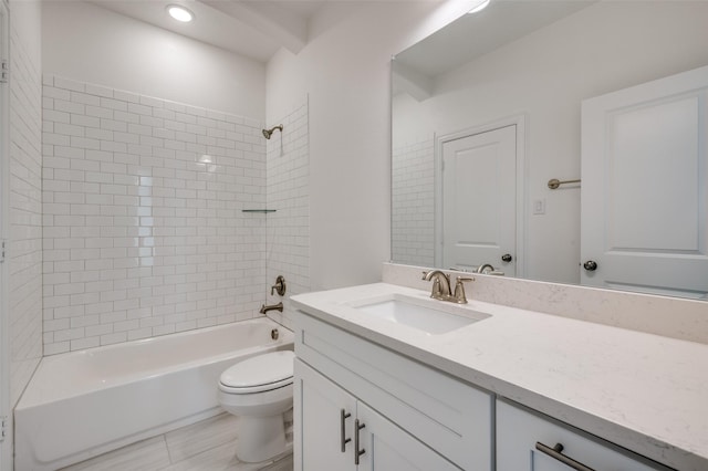 full bathroom featuring tile patterned floors, vanity, tiled shower / bath combo, and toilet