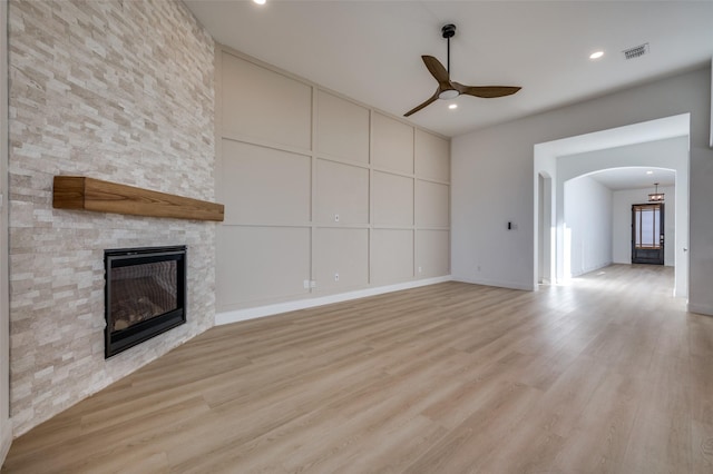 unfurnished living room featuring a fireplace, light hardwood / wood-style flooring, and ceiling fan