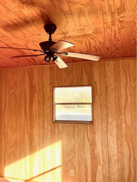 details with ceiling fan, wood ceiling, and wood walls