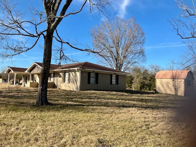 view of side of property with a lawn and a storage shed