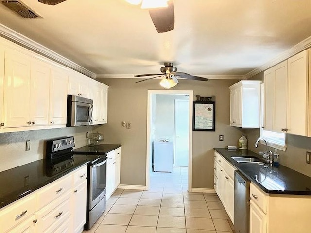 kitchen featuring white cabinets, stainless steel appliances, sink, light tile patterned floors, and crown molding