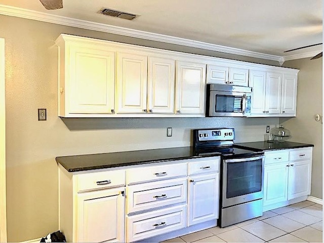 kitchen featuring light tile patterned floors, white cabinetry, appliances with stainless steel finishes, and crown molding