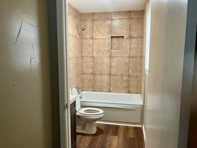 full bathroom featuring hardwood / wood-style floors, toilet, vanity, and tiled shower / bath