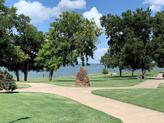 view of property's community featuring a lawn and a water view