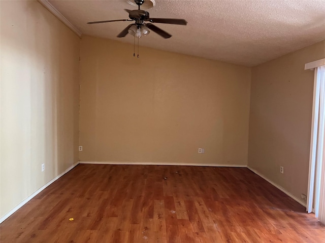 empty room with ceiling fan, wood-type flooring, and a textured ceiling