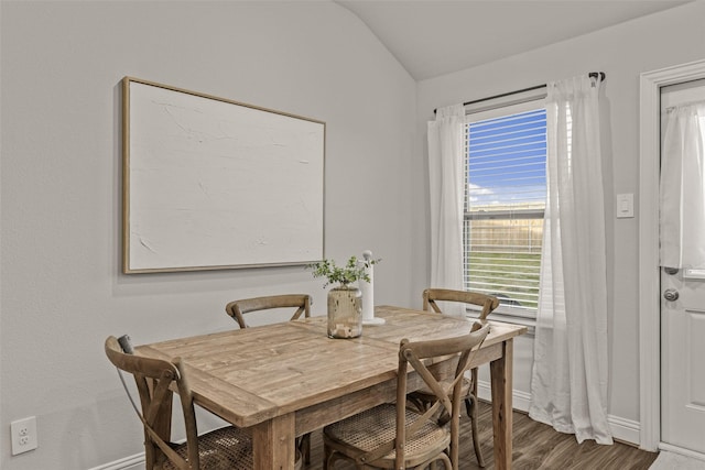 dining room featuring hardwood / wood-style floors and vaulted ceiling