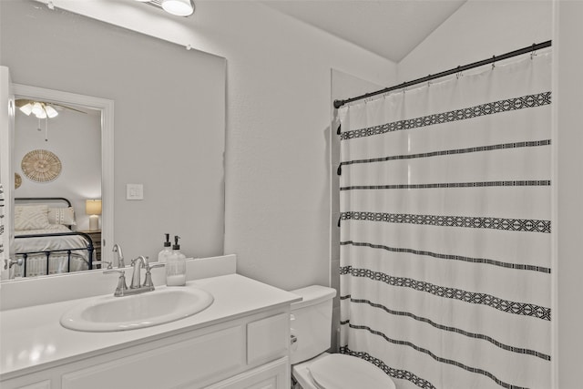 bathroom with vaulted ceiling, curtained shower, vanity, and toilet