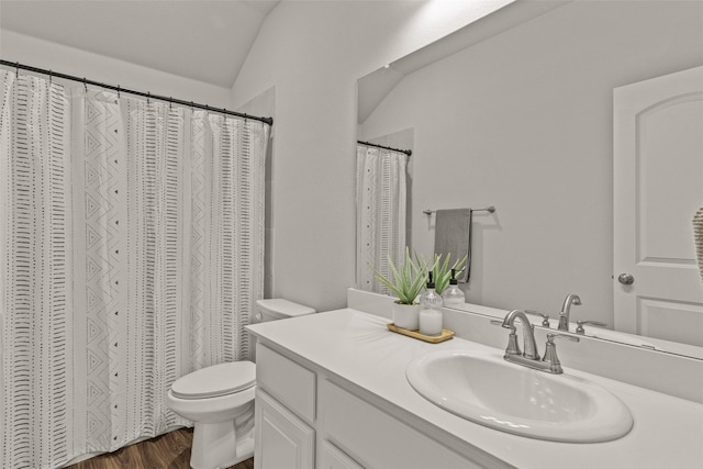 bathroom with lofted ceiling, toilet, hardwood / wood-style floors, and vanity