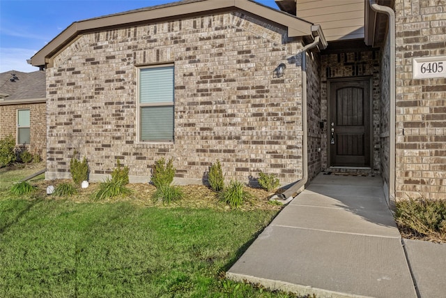 property entrance with a lawn