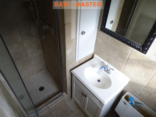 bathroom with vanity, tile walls, an enclosed shower, and tile patterned floors