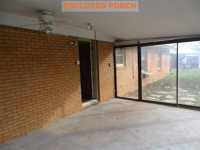 unfurnished sunroom with ceiling fan