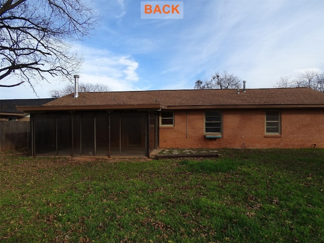 rear view of property with a yard and a sunroom