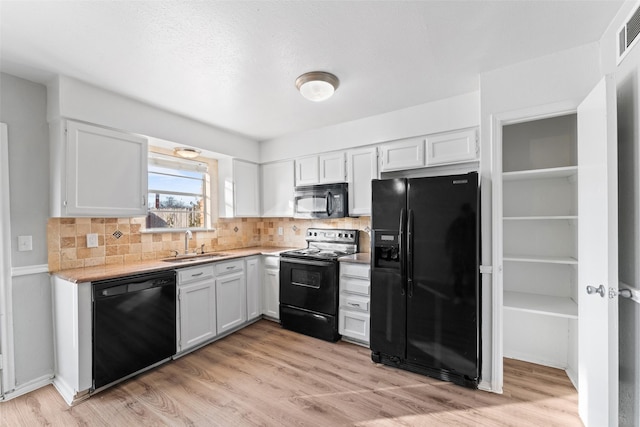 kitchen with white cabinets, decorative backsplash, sink, and black appliances