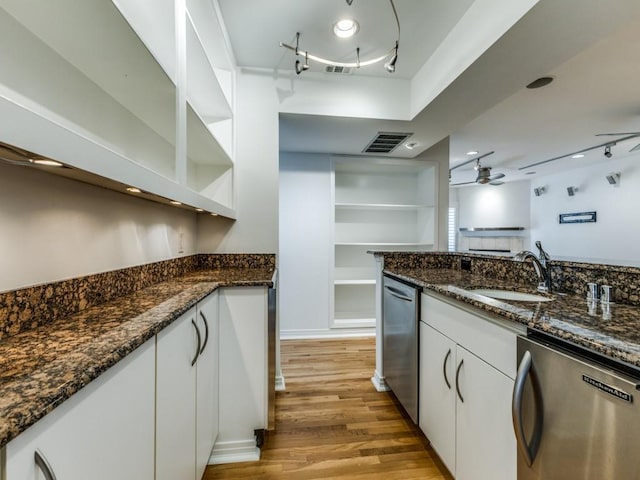 kitchen with ceiling fan, dishwasher, sink, dark stone countertops, and white cabinets