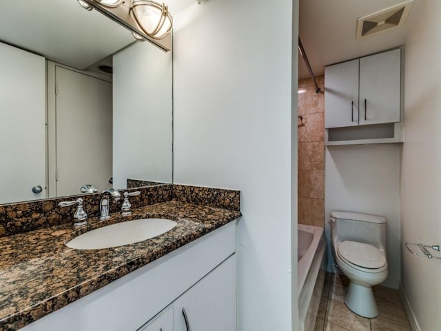 full bathroom featuring tile patterned floors, vanity, tiled shower / bath combo, and toilet