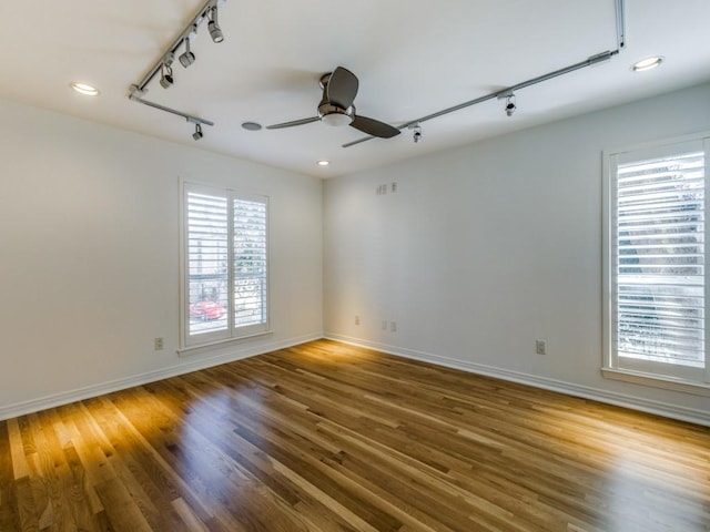 spare room featuring ceiling fan, hardwood / wood-style floors, and track lighting