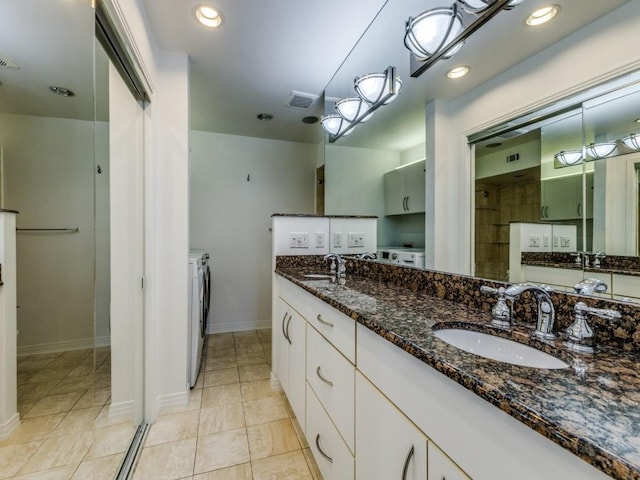 bathroom featuring tile patterned floors, vanity, and washer and dryer