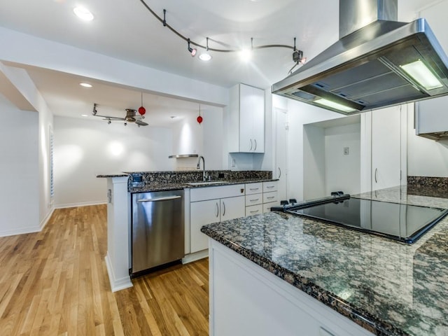 kitchen featuring white cabinetry, sink, stainless steel dishwasher, dark stone countertops, and island range hood