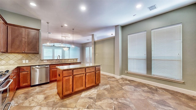 kitchen with backsplash, stainless steel appliances, sink, decorative light fixtures, and a center island