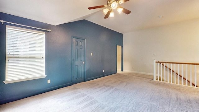 unfurnished room with ceiling fan, light colored carpet, and vaulted ceiling