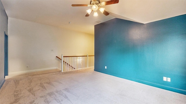 spare room featuring ceiling fan, light colored carpet, and lofted ceiling