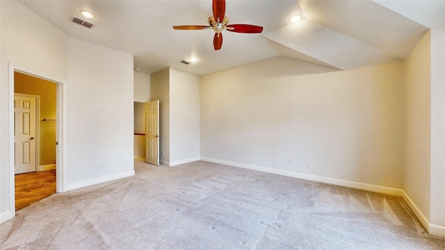 carpeted spare room featuring ceiling fan and lofted ceiling