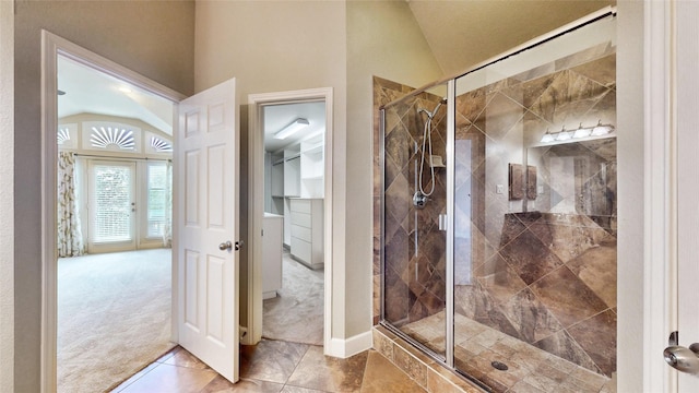 bathroom with french doors, vaulted ceiling, and a shower with shower door