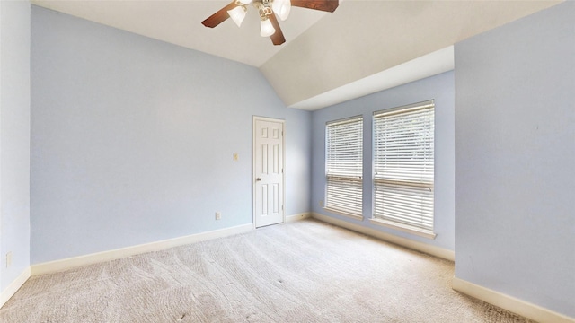 empty room featuring ceiling fan, light carpet, and vaulted ceiling