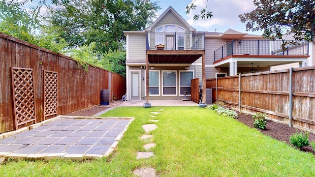 rear view of house with a yard and a balcony