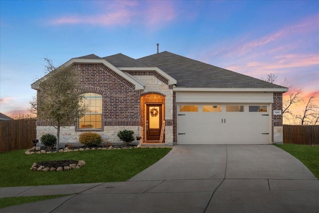 view of front of home featuring a garage and a yard