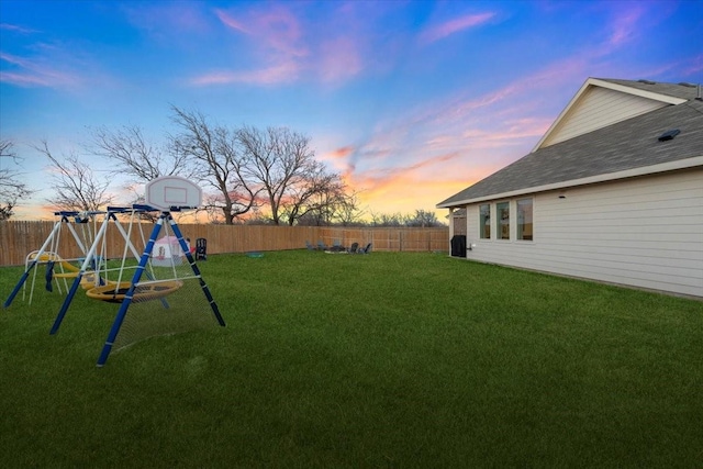 yard at dusk featuring a playground