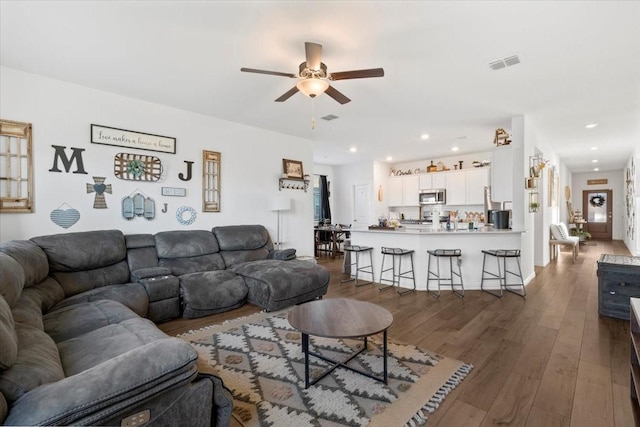 living room featuring ceiling fan and dark hardwood / wood-style floors