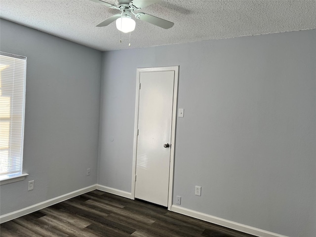 unfurnished room with ceiling fan, dark hardwood / wood-style flooring, and a textured ceiling