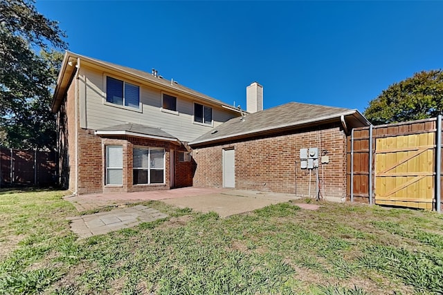 rear view of property with a lawn and a patio