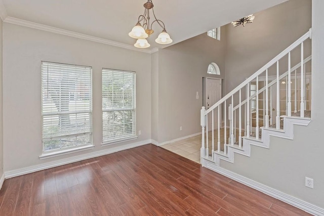 5400 Belle Chasse Ln, Frisco, TX 75035 - foyer featuring a chandelier, stairway, wood finished floors, baseboards, and ornamental molding