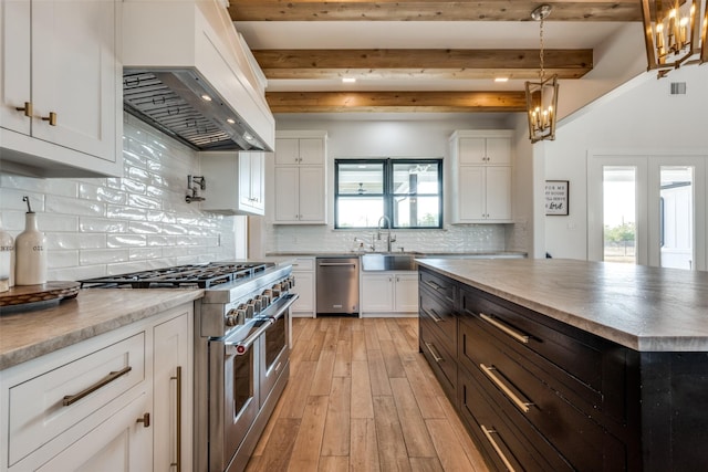 kitchen featuring appliances with stainless steel finishes, pendant lighting, white cabinetry, sink, and custom exhaust hood