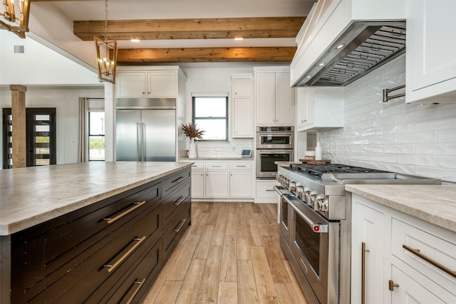 kitchen with beamed ceiling, premium appliances, white cabinetry, and custom exhaust hood