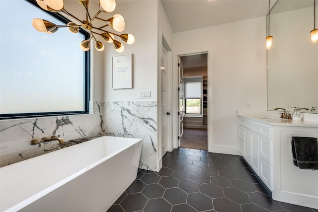 bathroom featuring tile patterned floors, a washtub, vanity, and a chandelier