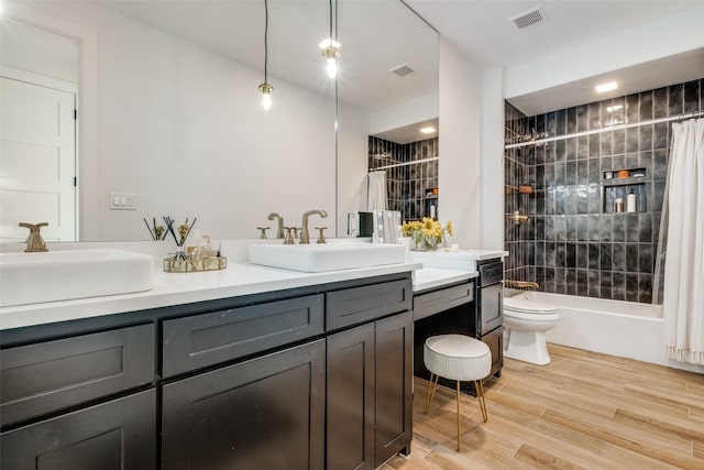 full bathroom featuring toilet, wood-type flooring, vanity, and shower / tub combo with curtain