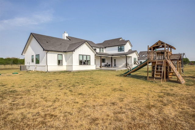 back of house with a yard and central AC