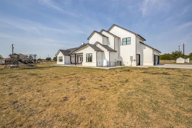 rear view of house featuring a lawn and a garage