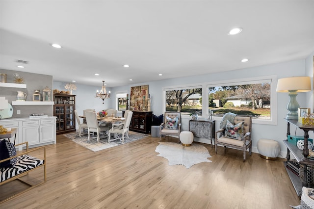 interior space featuring an inviting chandelier and light hardwood / wood-style flooring