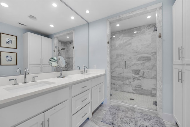 bathroom featuring a shower with shower door and vanity