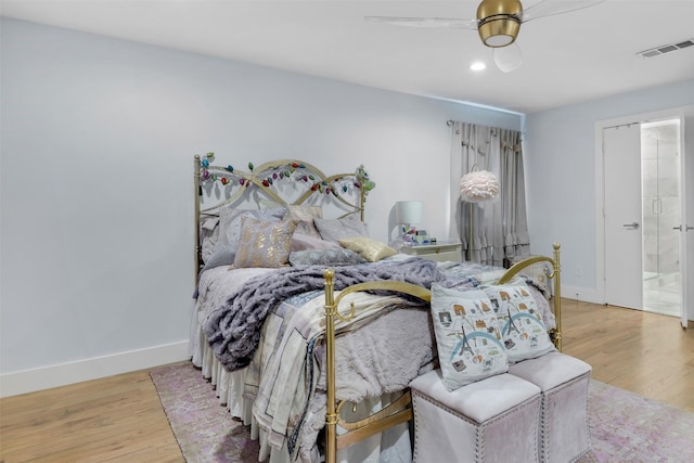 bedroom with ensuite bath, ceiling fan, and light hardwood / wood-style flooring