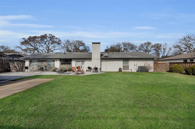 rear view of house with a lawn, central AC unit, and a patio area