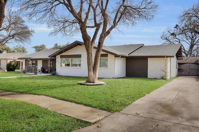 ranch-style house with a garage and a front lawn