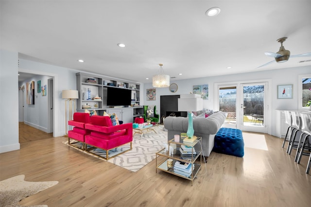 living room with ceiling fan, light hardwood / wood-style floors, and french doors