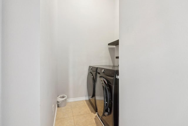 washroom with independent washer and dryer and light tile patterned flooring