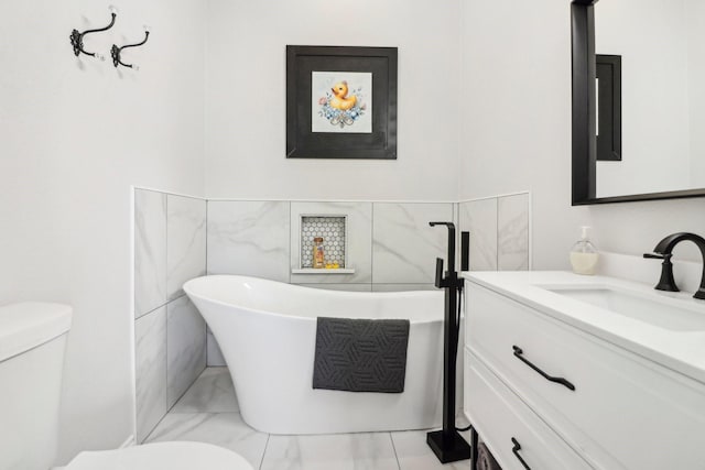 bathroom featuring vanity, a bathtub, and toilet