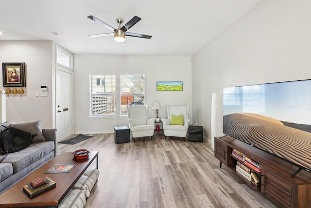 living room with wood-type flooring, beamed ceiling, and ceiling fan